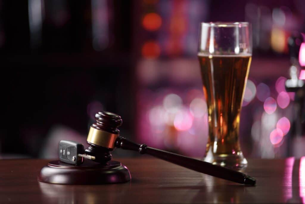An alcoholic beverage, with a set of car keys and a judge's gavel, representing how one can benefit from calling a Portland criminal defense lawyer.