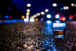 Can a Person Be Convicted of Sexual Assault if Both Parties Were Intoxicated in Maine portrayed by a whiskey glass on the road at night in downtown Portland Maine.