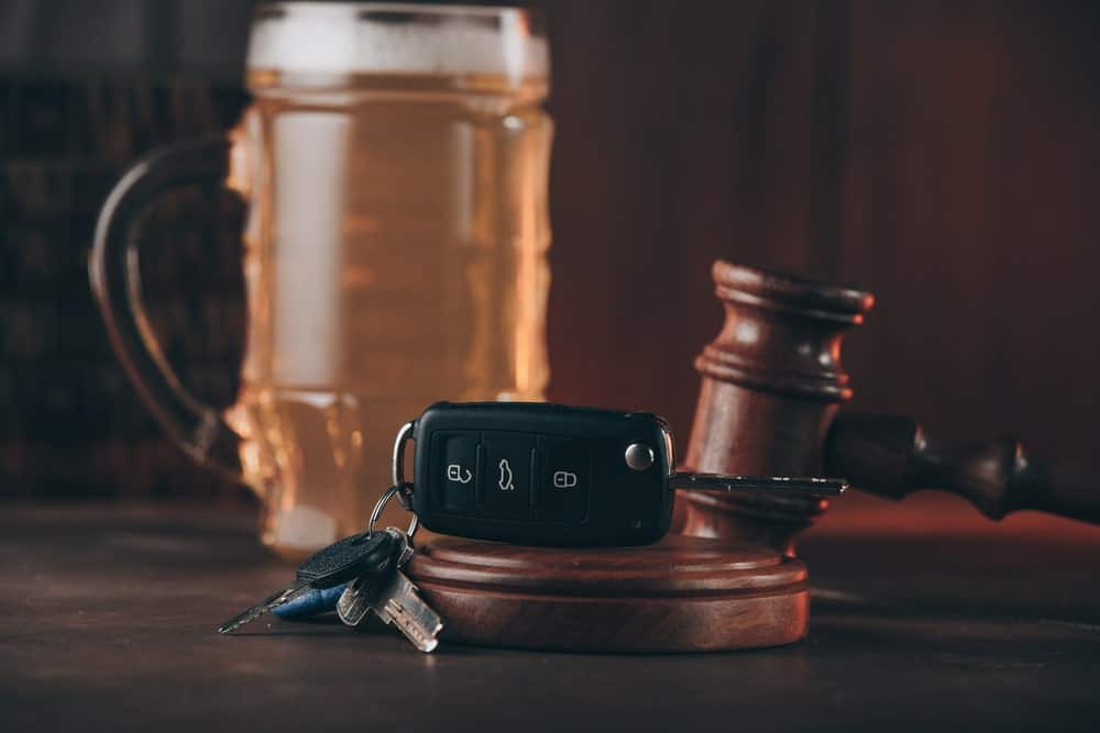 How to Successfully Beat an OUI Refusal in Maine portrayed by a beer in a Maine court room near a gavel.