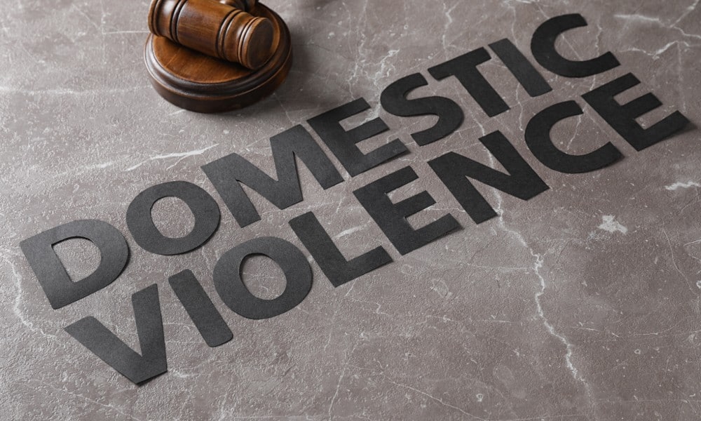 How a Domestic Violence Conviction Can Affect Your Life portrayed by the words "domestic violence" on the concrete next to a gavel.